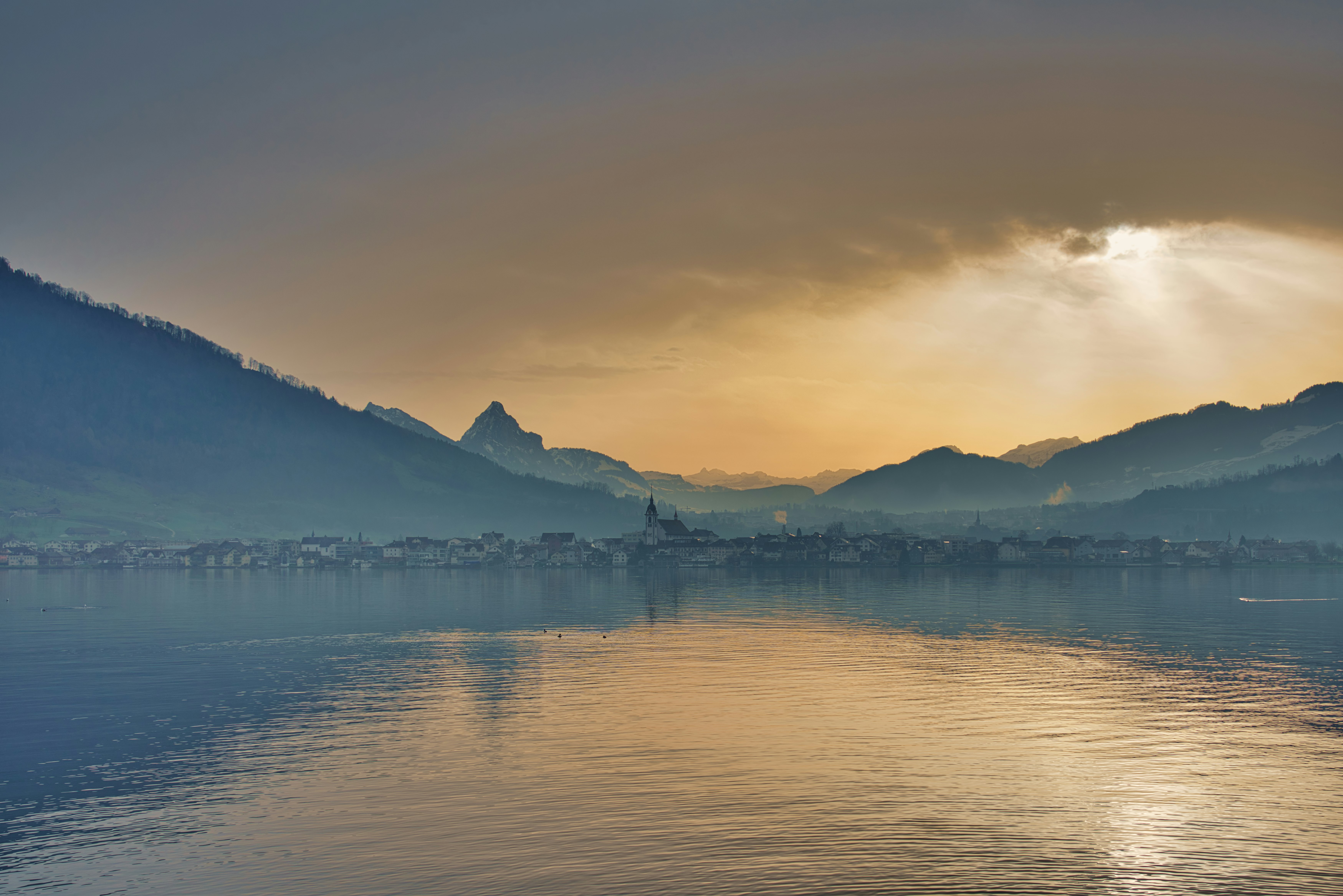 body of water near mountain during daytime